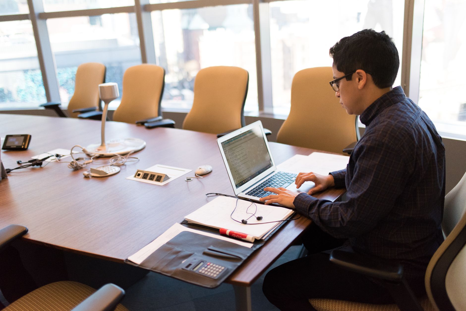 Engineer working through architecture decisions on a laptop in a conference room